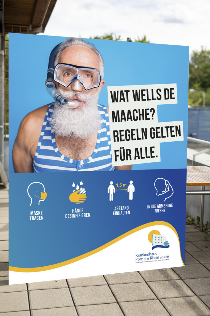 Opa mit Taucherbrille und Schnorchel auf Rollup, Aktion zum Corona Schutz Krankenhaus Köln-Porz