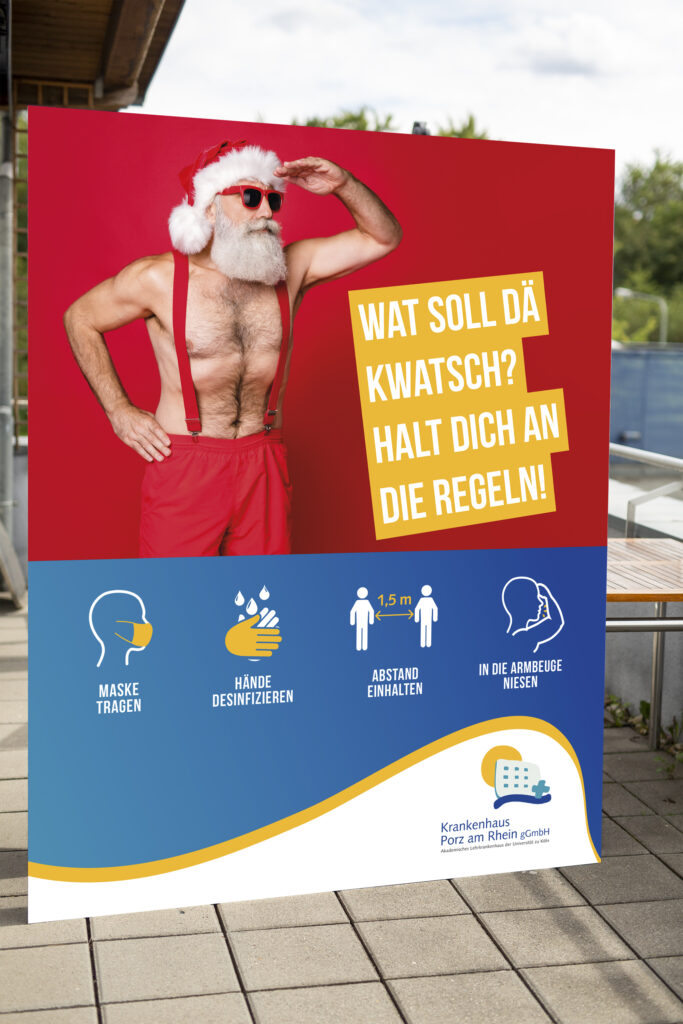 Weihnachtsmann mit Sonnenbrille der in die Ferne schaut auf Rollup , Aktion zum Corona Schutz Krankenhaus Köln-Porz
